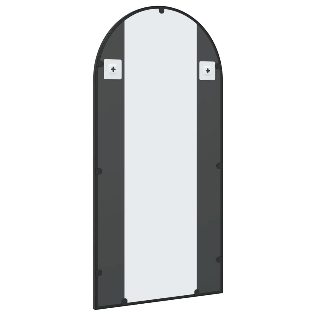 Detail of black iron frame on minimalist arched mirror highlighting powder-coated finish and clean lines