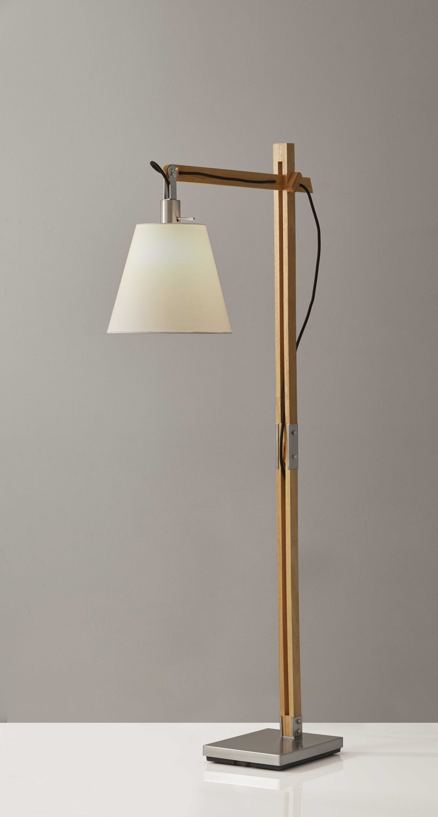Natural wood floor lamp with adjustable hinged arm featuring Scandinavian design, perfect for reading and task lighting in modern living spaces