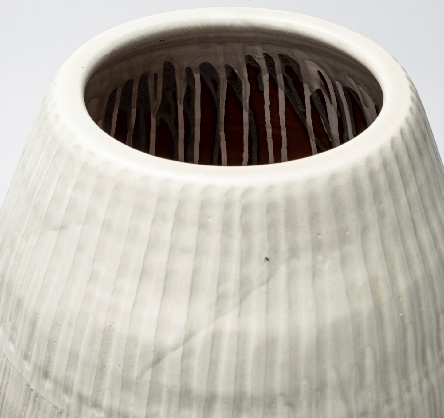 Close-up of a textured ceramic vase with a light gray color.