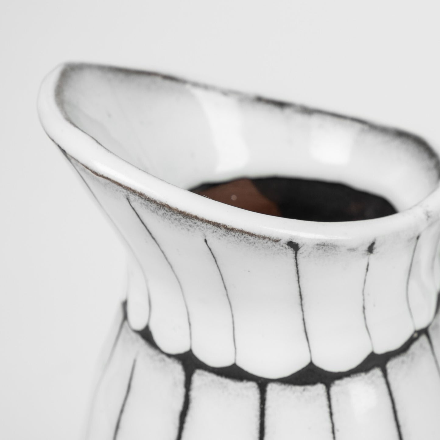White and black artisan ceramic pitcher detail showing premium quality and handcrafted glazing technique