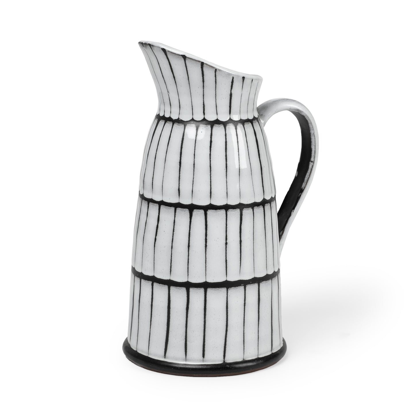 Close-up of white and black ceramic pitcher showing creamy white glaze bleeding effect and dark clay details with angular spout