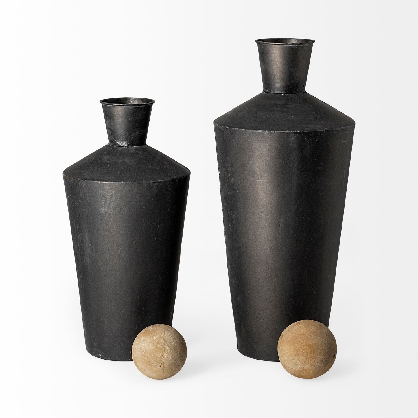 Close-up of distressed matte black finish on contemporary metal cylindrical urn with brown undertones