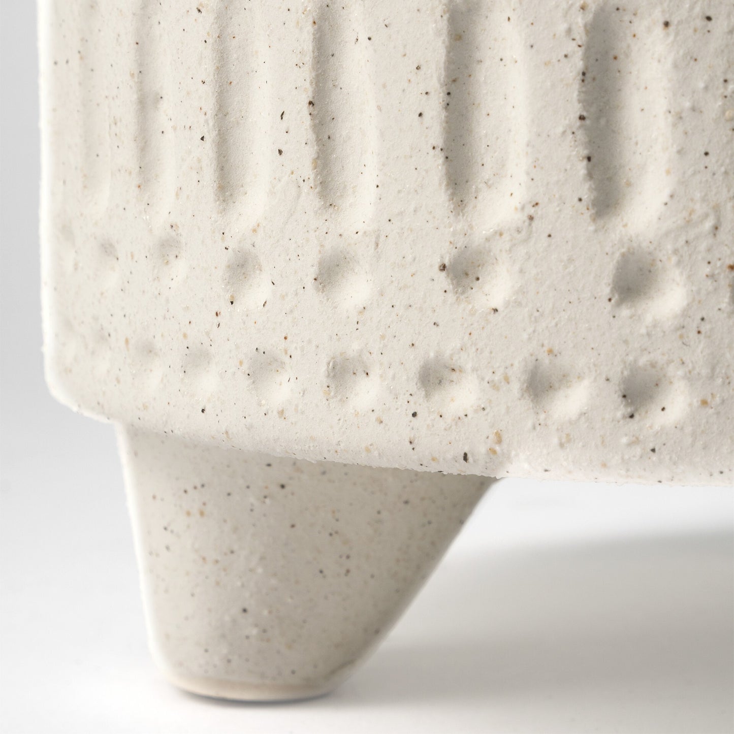 Happy face tribal vase showing textured beige finish and carved details, playful ceramic decor for eclectic home accents