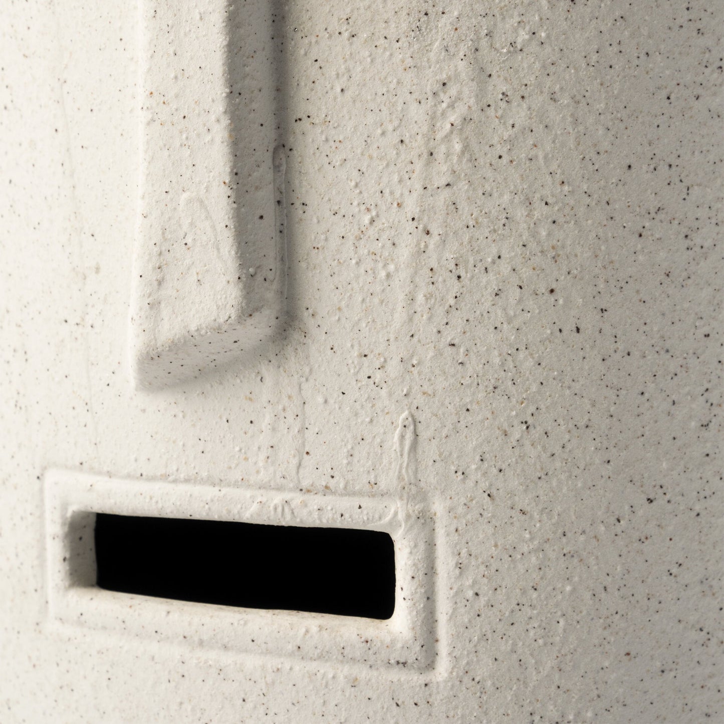 Detail shot of carved tribal patterns and textured beige finish on ceramic planter vase