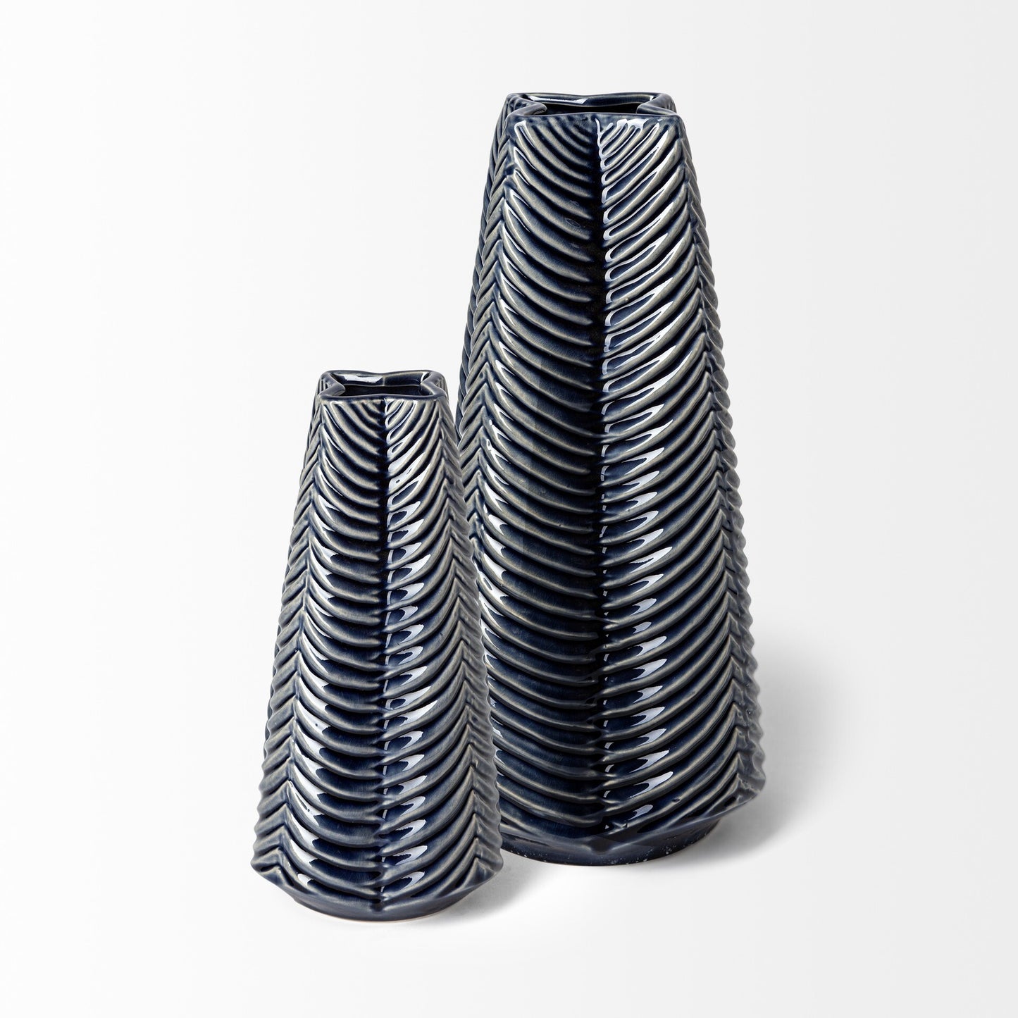 Close-up detail of carved striped pattern on navy blue ceramic vase showing translucent glaze that reveals underlying texture and artisan craftsmanship