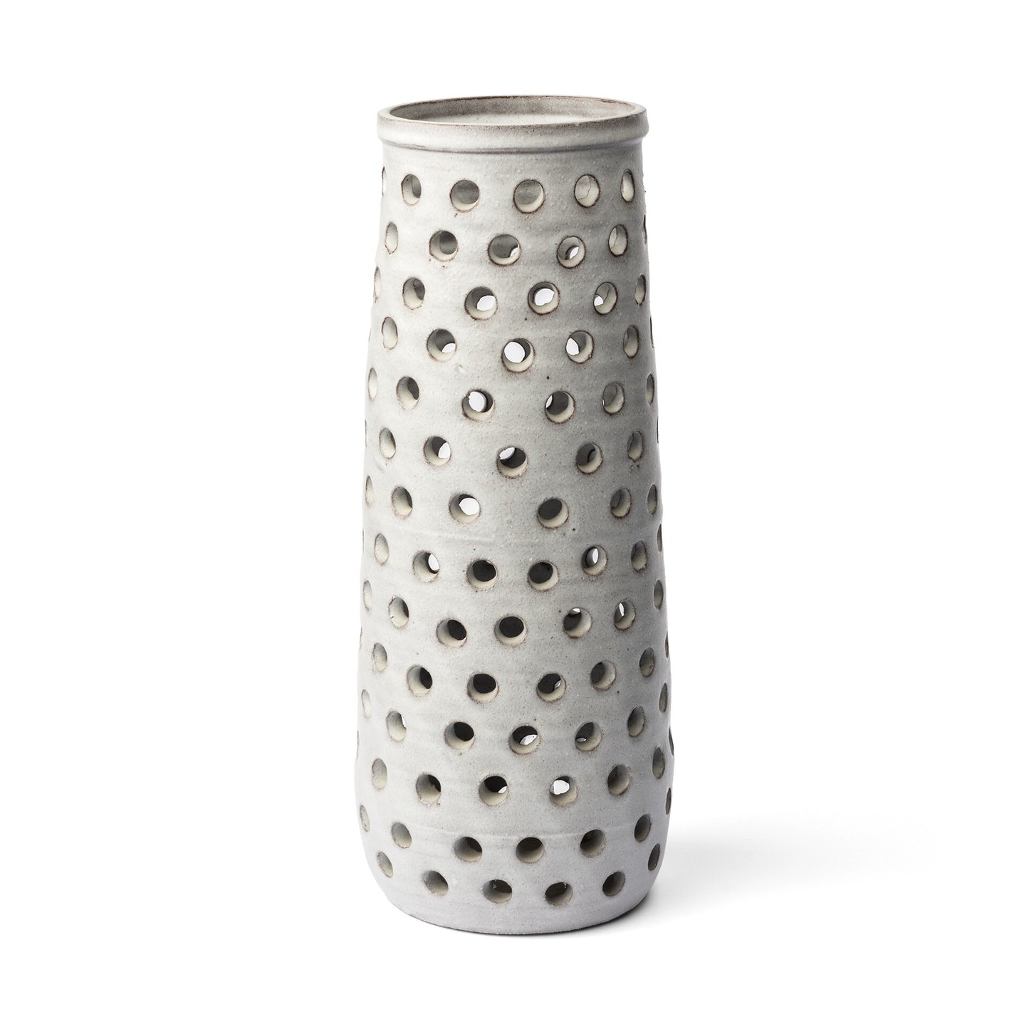 Close-up of pierced dot openwork pattern on white glazed ceramic vase creating light and shadow effects