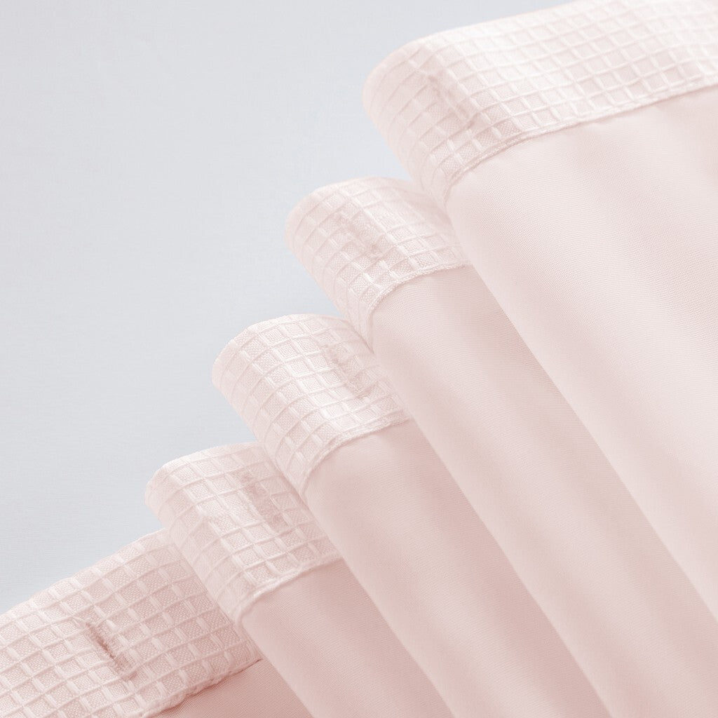 Detail shot of blush pink shower curtain grid pattern and cotton material quality