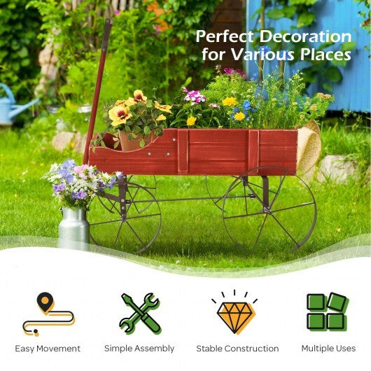 Red wooden wagon planter with wheels in garden setting with colorful flowers