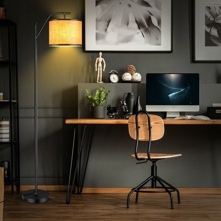 Full view of contemporary floor lamp with beige shade in living room setting, showcasing foot switch control and stable base design