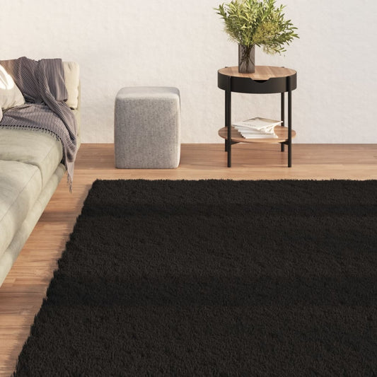 Black rectangular non-slip area rug 63x90 inches displayed in modern living room showing plush polyester texture
