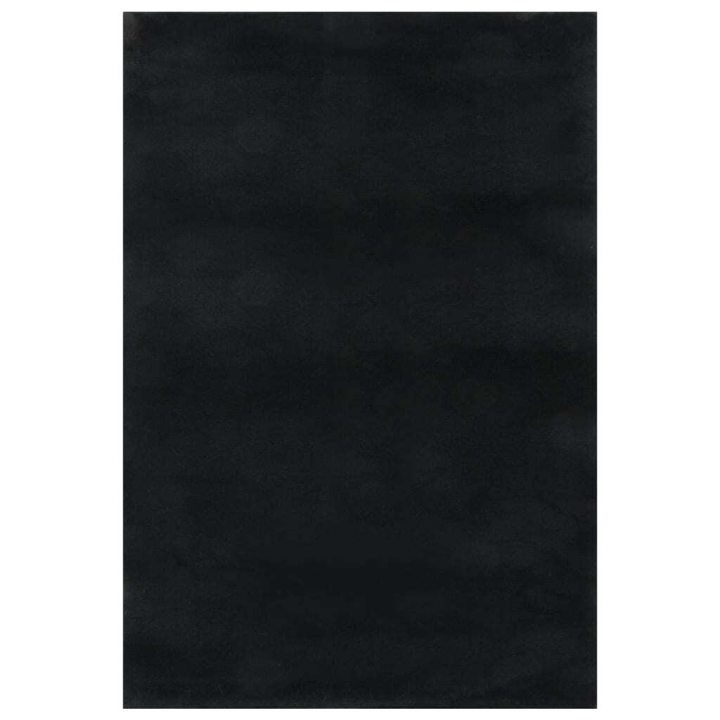 Close-up view of black area rug showing 100% polyester fabric construction and soft plush surface
