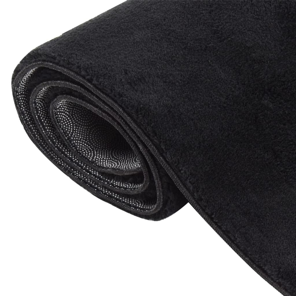 Black non-slip area rug texture close-up showing machine washable polyester fibers and quality
