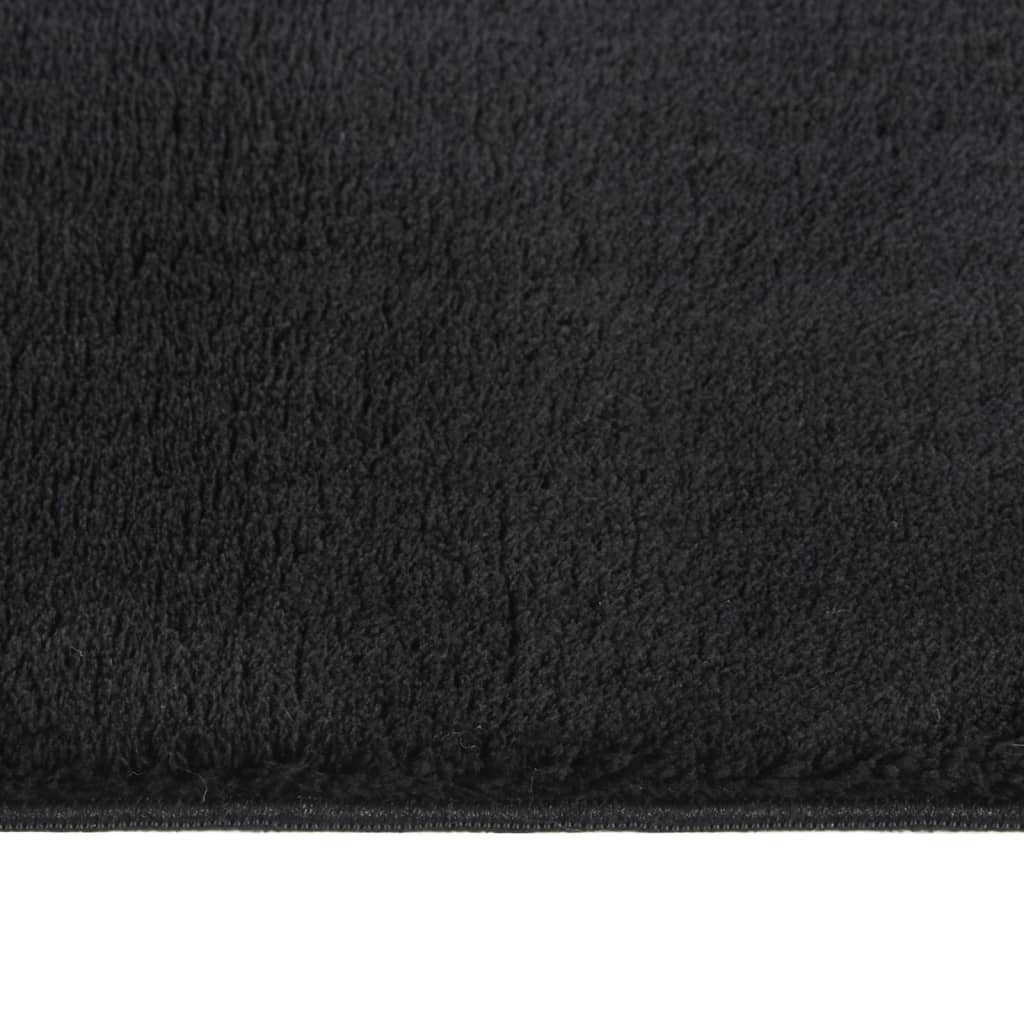 Black rectangular rug folded showing portability and easy storage for machine washing

