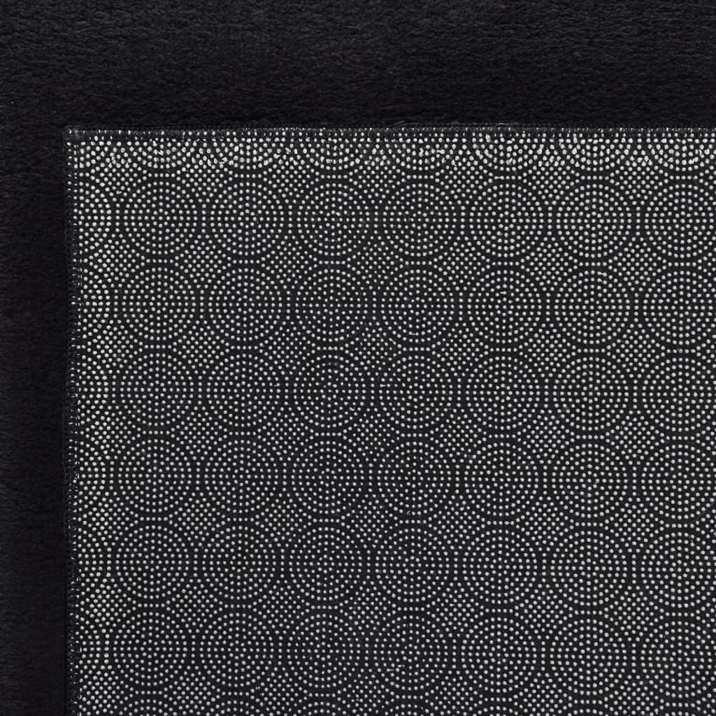 Black area rug non-slip backing detail showing secure grip surface and safety features

