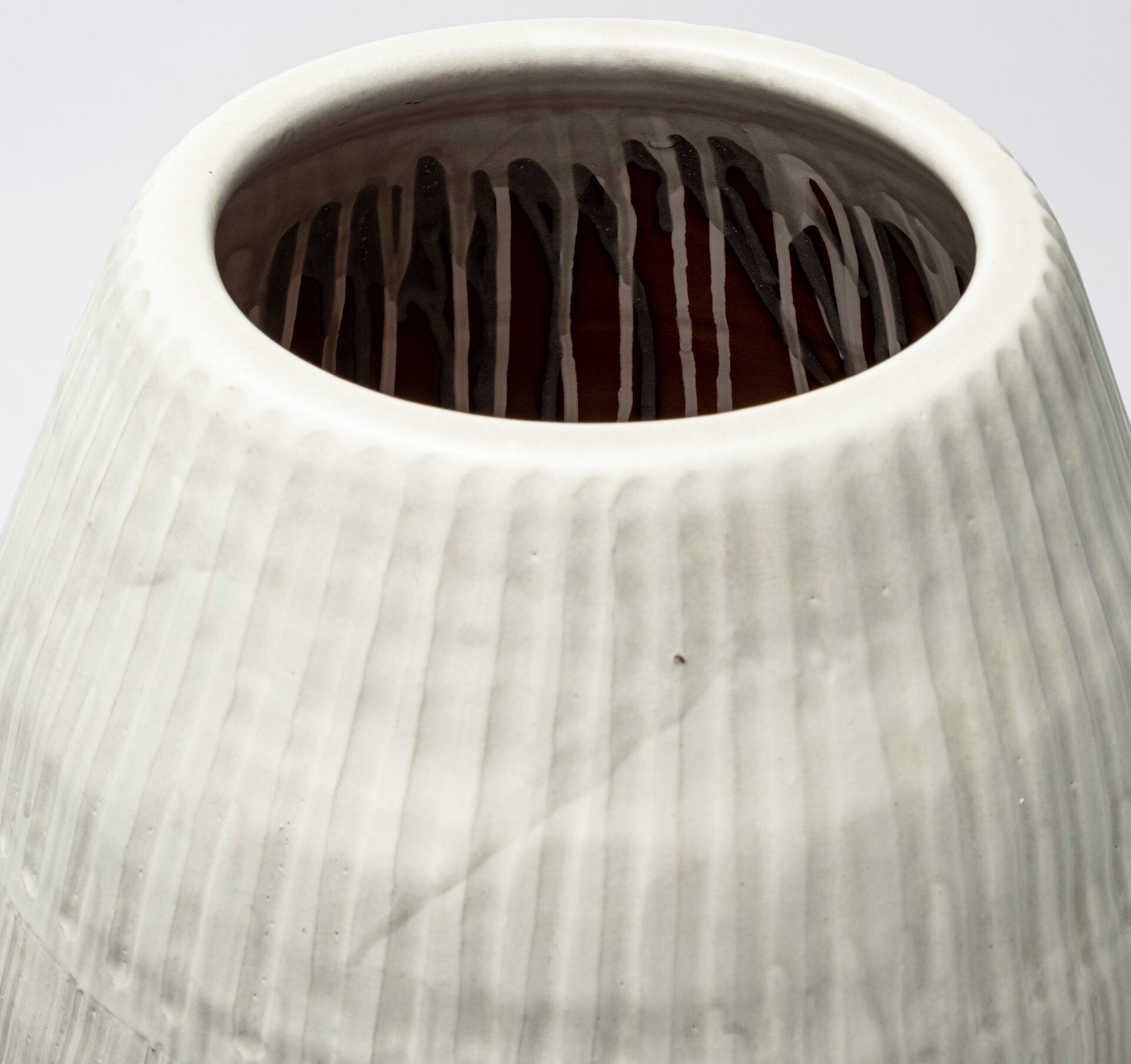 Close-up of a textured ceramic vase with a light gray color.