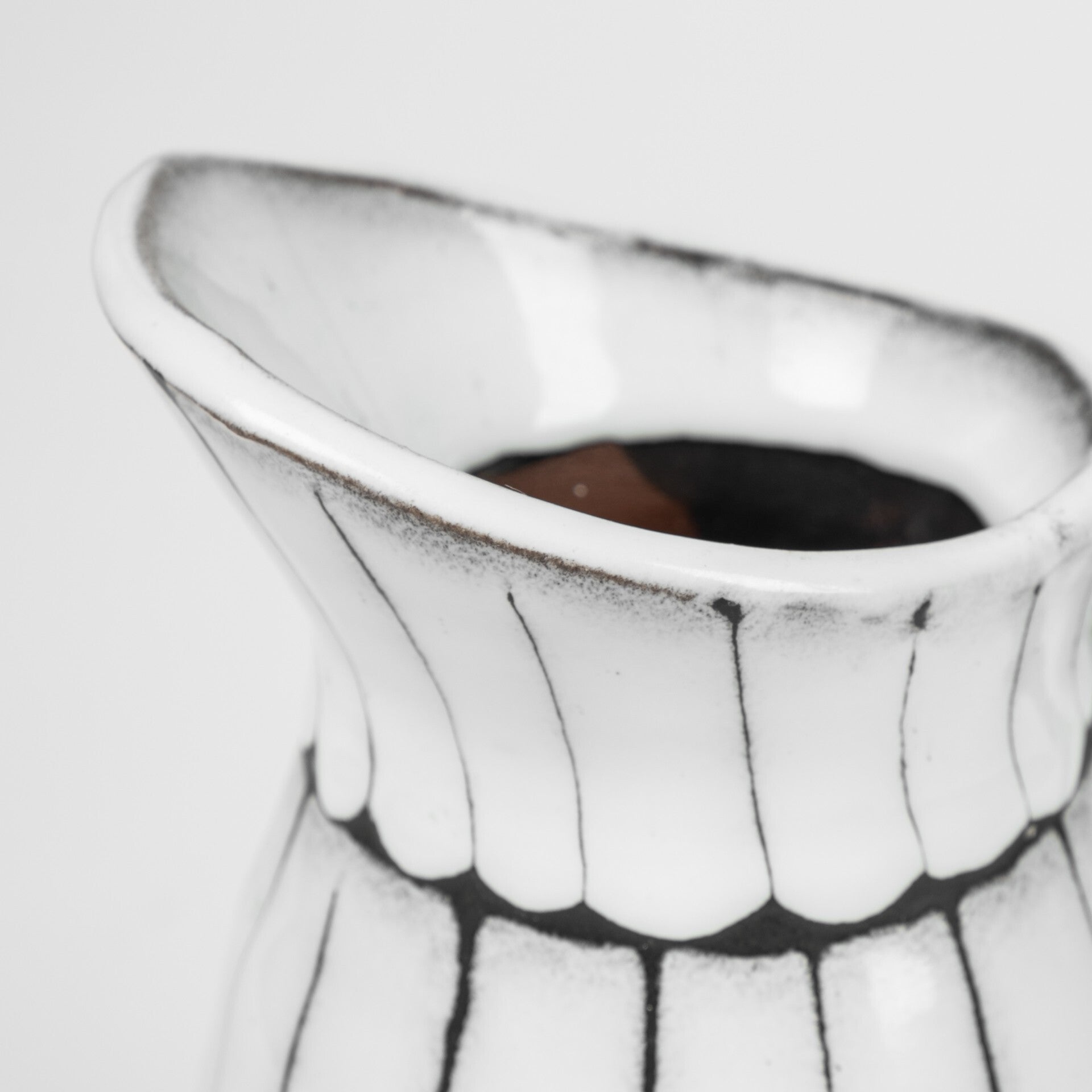 White and black artisan ceramic pitcher detail showing premium quality and handcrafted glazing technique
