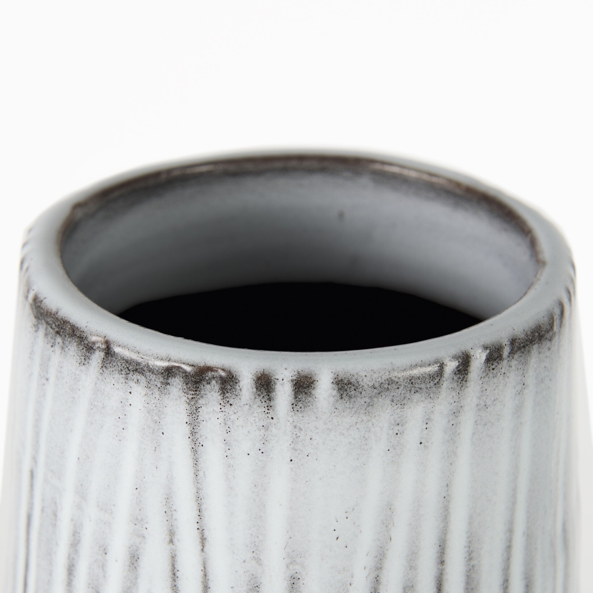 Three-quarter view of tall black and white ceramic vase emphasizing elegant curves and geometric striped texture, perfect for contemporary living room or office decor

