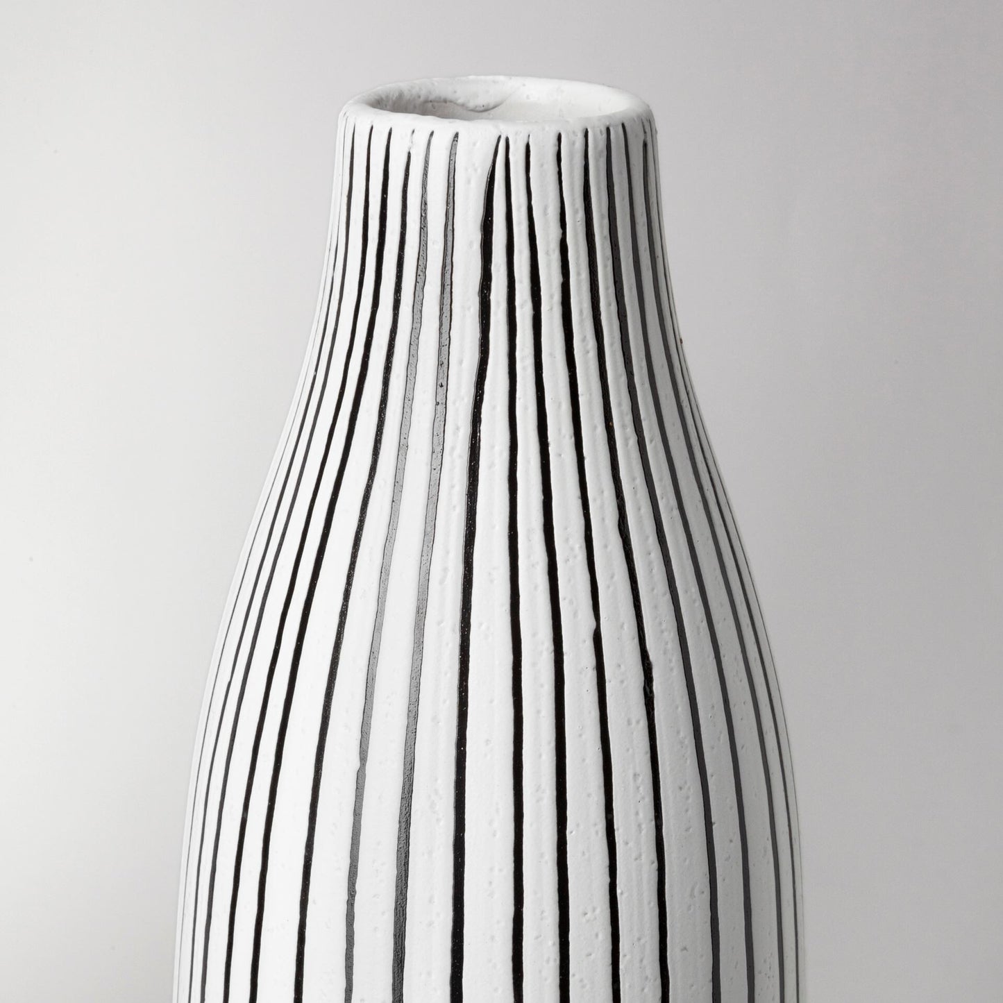 Black and white pinstripe vase detail showing premium ceramic construction and contemporary design
