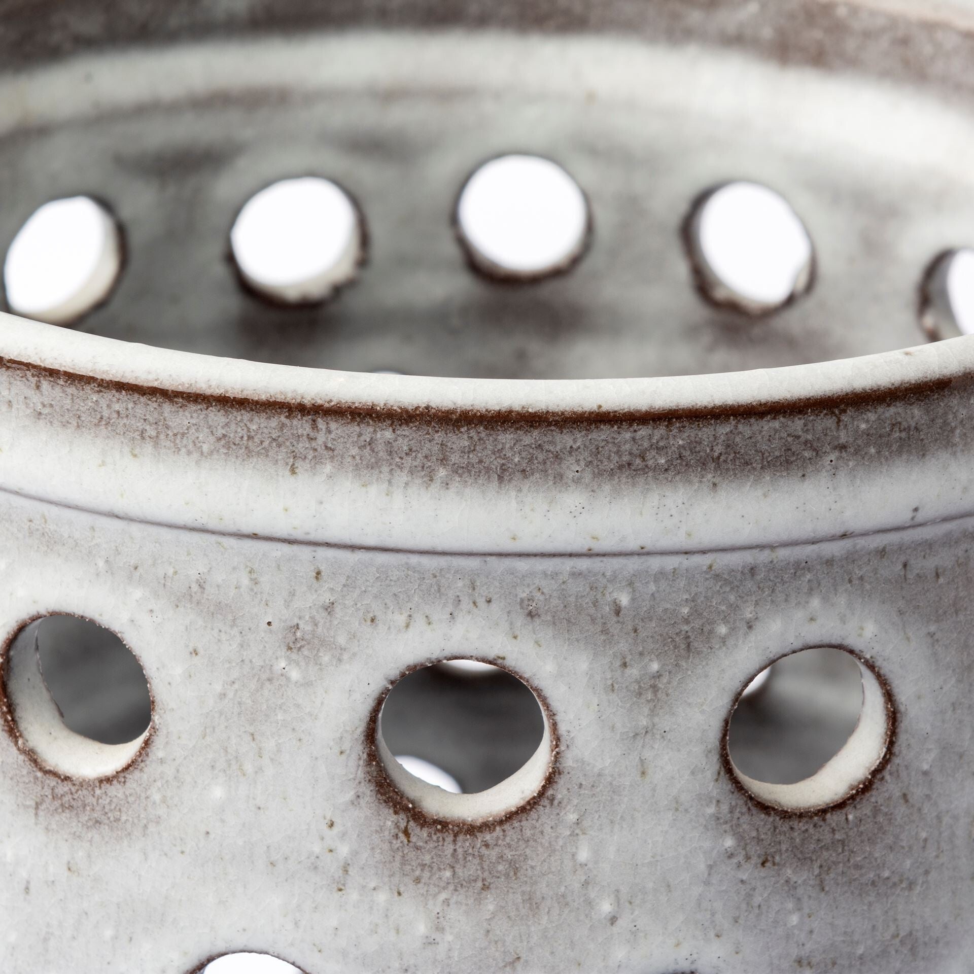 White pierced dot ceramic vase detail showing artisanal craftsmanship and lace-like openwork design
