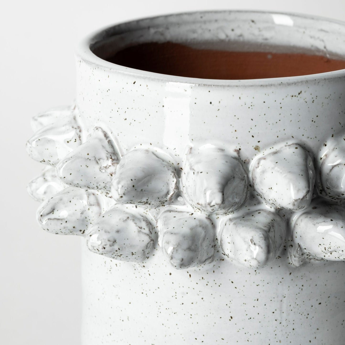 Close-up of organic speckled white glaze and 3D spikely detail on contemporary ceramic vase
