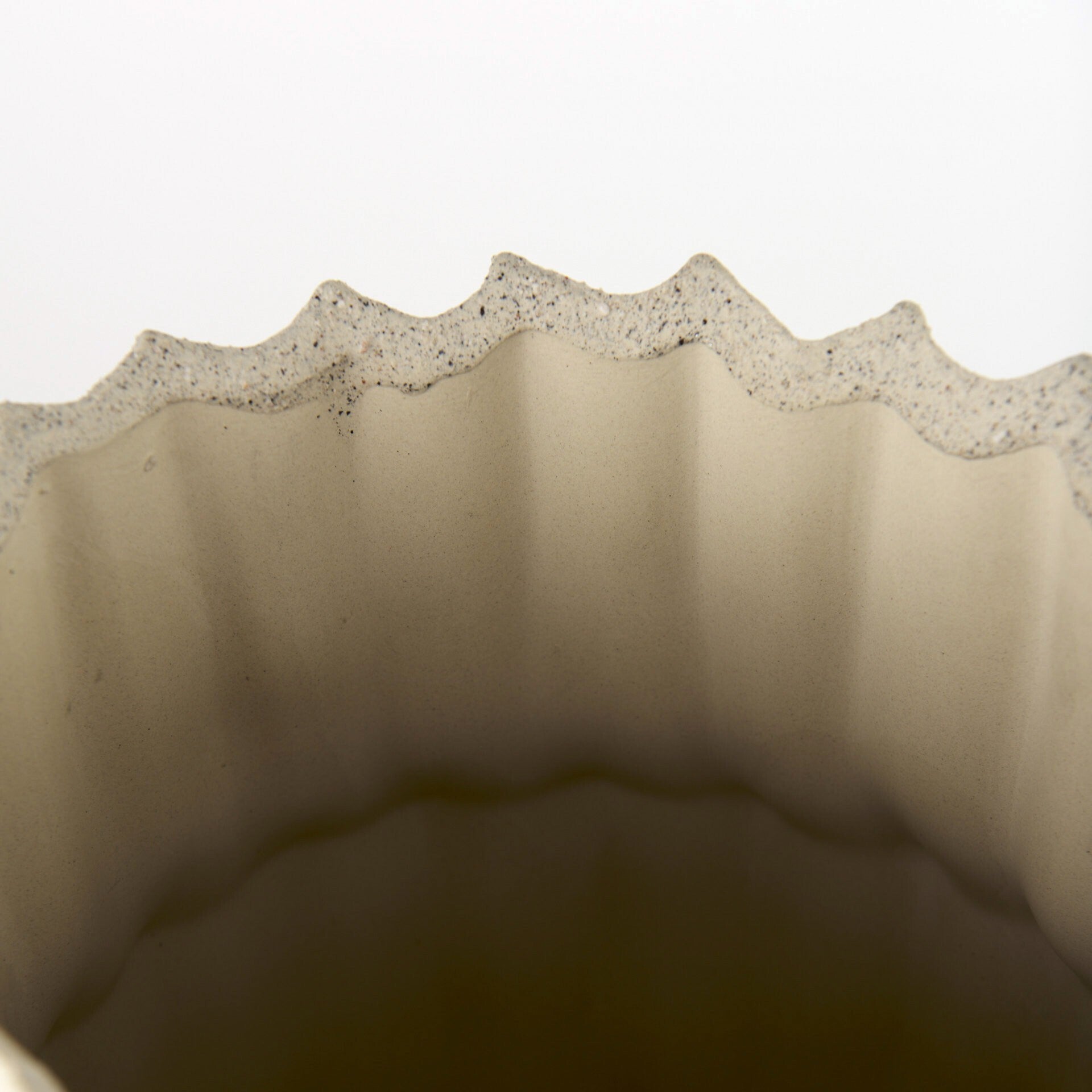 Organic textured sand vase with tall glass shape ideal for dramatic floral arrangements
