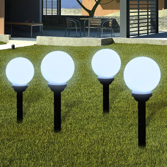 Set of 4 white solar-powered garden lights installed in outdoor landscape showing spherical design and LED illumination
