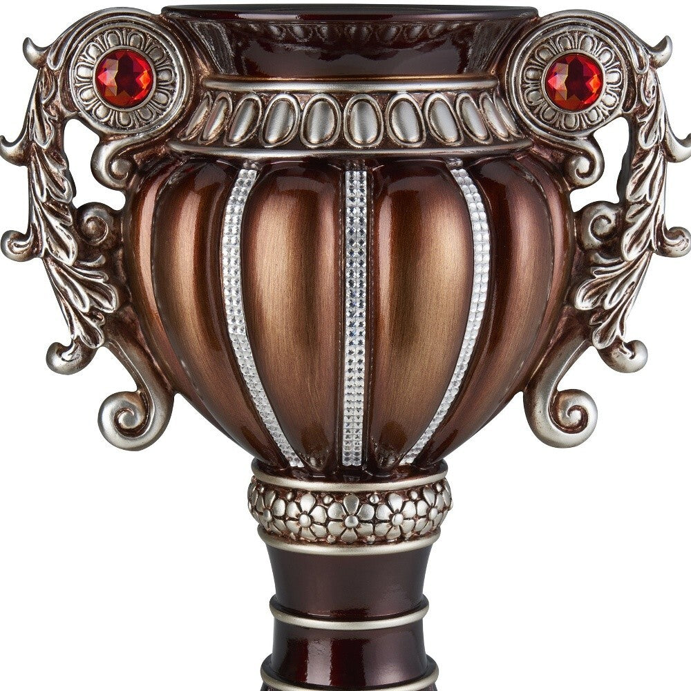 Detail shot of ornate floral pattern and stone embellishments on bronze silver polyresin vase
