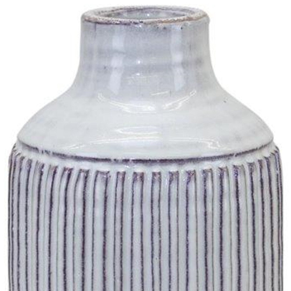 Off white carved ribbed vase displaying dimensional texture and natural terracotta material

